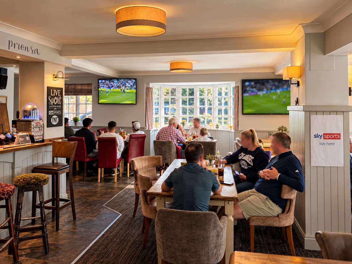 Guests watching football on the screens in The Prince of Wales sports lounge